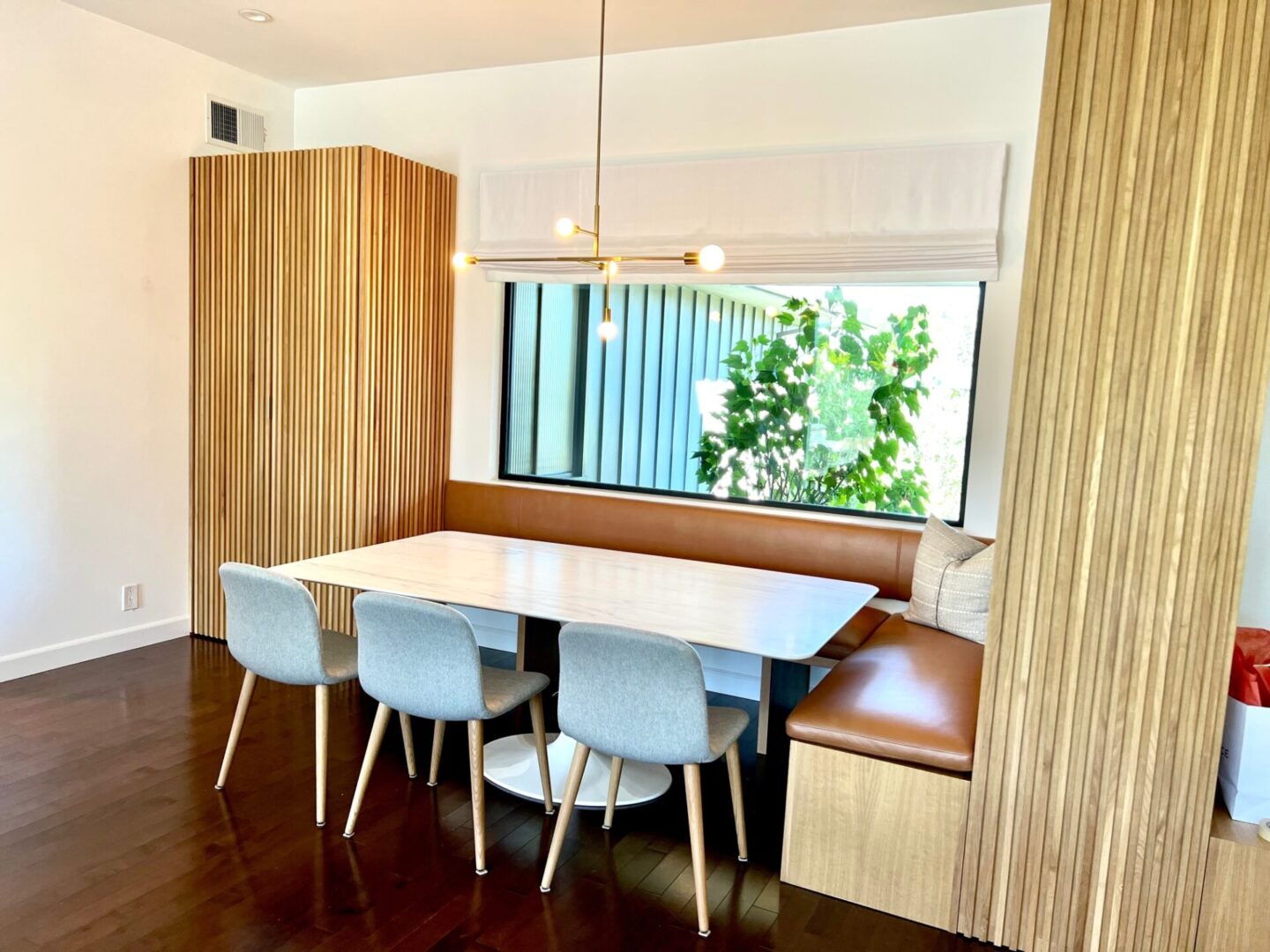 A dining room table with four chairs and a bench.