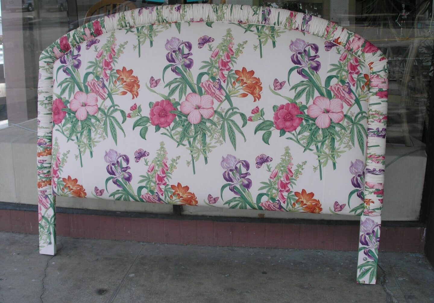 A floral print headboard with a matching chair.